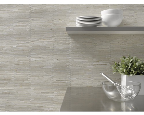 Wandgestaltung mit Mosaikfliesen und Küchenutensilien auf einem Regal.