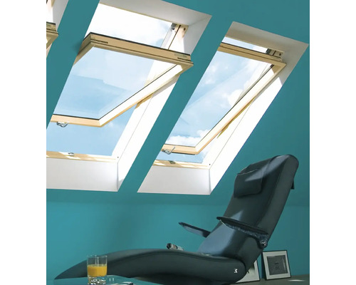 Intérieur avec fenêtres de toit, fauteuil et verre de jus d''orange