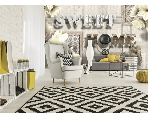 Salon avec fauteuil, canapé, tapis et papier peint mural avec l''inscription Sweet Home