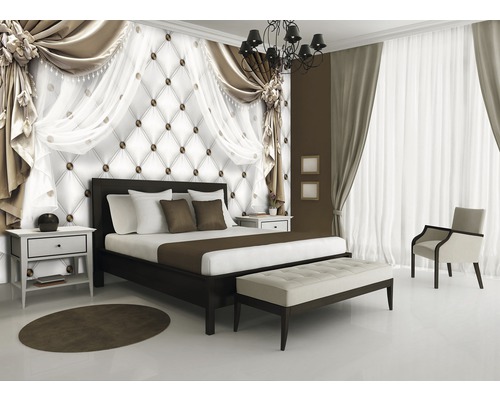 Schlafzimmer mit Bett, Nachttisch, Sitzbank, Sessel, Teppich und dekorativer Wandgestaltung