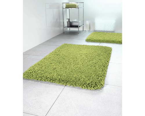 Badezimmer Szene mit zwei grünen Badteppichen und einem Regal