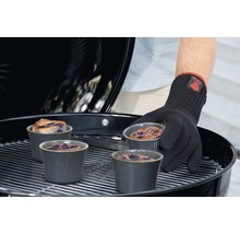 Scène de barbecue avec dessert dans des moules sur une grille, protégé par un gant de barbecue