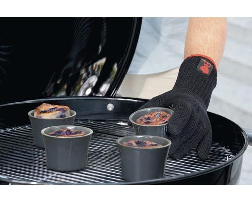 Scène de barbecue avec dessert dans des moules sur une grille, protégé par un gant de barbecue