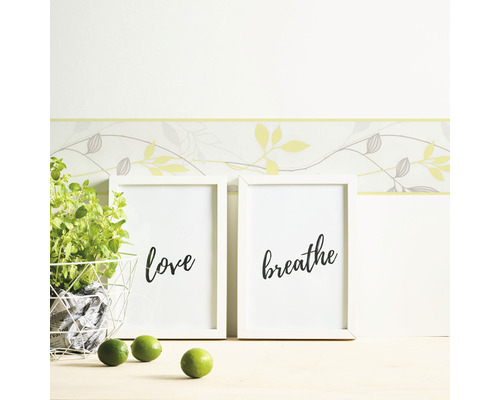 Wandgestaltung mit Bordüre, Bilderrahmen mit den Wörtern Liebe und Atmen, Topfpflanze und Limetten