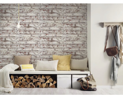 Intérieur avec papier peint aspect brique, banc avec coussins et rangement pour le bois.