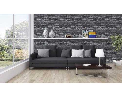 Salon avec papier peint imitation briques, canapé, table et décoration pour une ambiance chaleureuse.