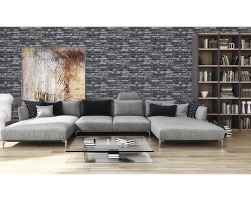 Salon avec papier peint en briques grises, canapé et bibliothèque