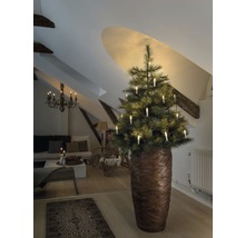 Sapin de Noël avec bougies dans un salon sous un toit mansardé