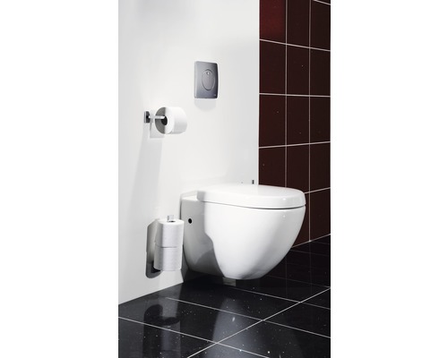 Wandhängendes WC mit Toilettenpapierhalter und Betätigungsplatte in einem Badezimmer