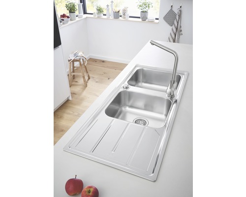 Évier de cuisine en acier inoxydable avec égouttoir et robinet dans une cuisine lumineuse