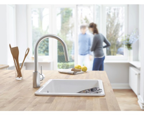 Scène de cuisine avec évier, robinet et plan de travail en bois