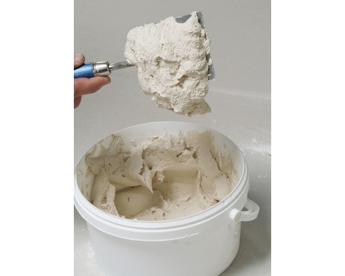 Spachtelmasse in einem Eimer mit einem Spachtel