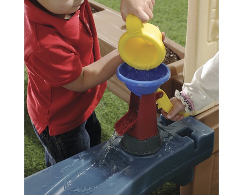 Les enfants jouent avec une gouttière et un filtre à eau.