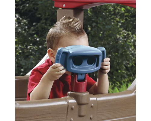 Un enfant joue avec des jumelles jouet sur une tour de jeu