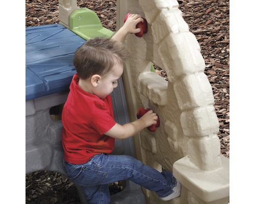 Bambin escaladant un mur d''escalade en plastique dans une aire de jeux