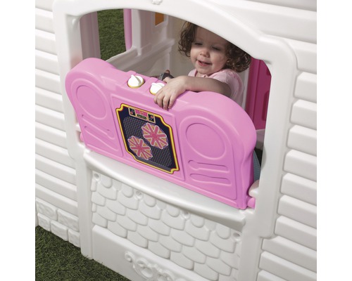 Cabane de jeu avec un enfant regardant par la fenêtre et tenant une radio jouet rose