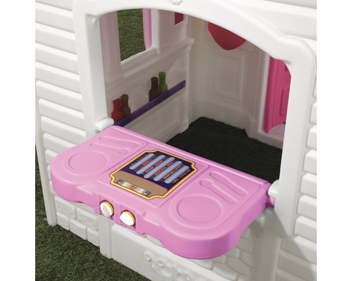 Détail d''une maisonnette avec un comptoir rose et de petites étagères à l''intérieur