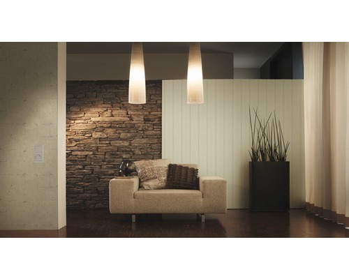 Wohnzimmer mit Sessel, Steintapete und Pendelleuchten