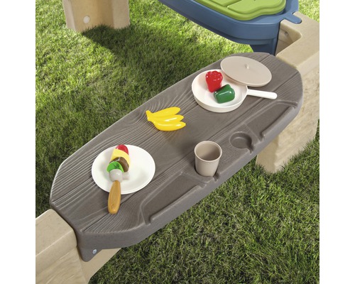 Gros plan sur une table de jeu avec des aliments jouets dans le jardin.