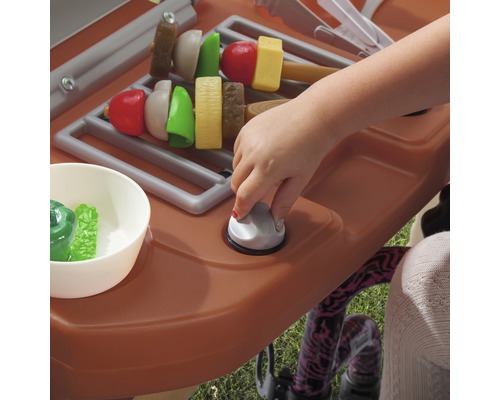 Cuisine enfant avec fonction grill et aliments jouets, utilisée par un enfant