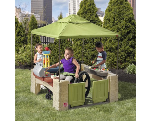 Cuisine de jeu avec toit de protection solaire et enfants dans le jardin