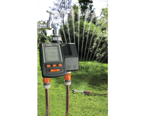 Programmateur d''arrosage Gardena avec tuyau d''arrosage et arroseur de pelouse connectés en fonctionnement