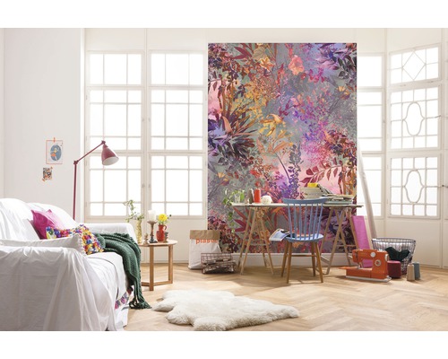 Salon avec papier peint photo floral, canapé et table de travail devant une fenêtre