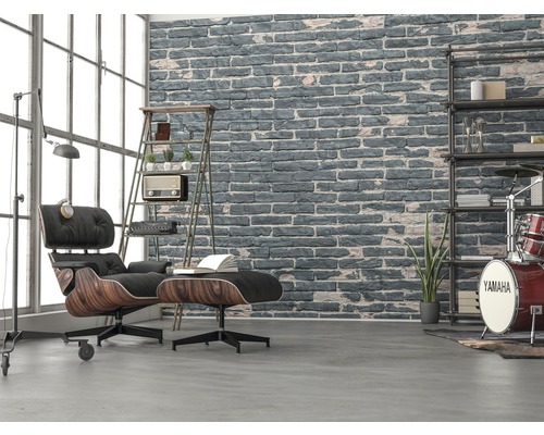 Salon avec fauteuil, tabouret, étagère et mur de briques