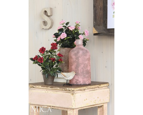 Scène décorative avec fleurs artificielles, oiseau et vase sur une table