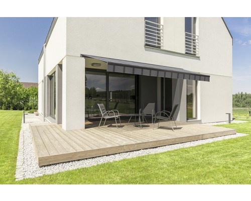 Maison moderne avec terrasse, store et mobilier de jardin