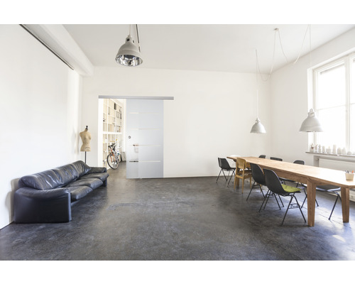 Pièce lumineuse avec canapé, porte coulissante, table et chaises