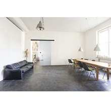 Heller Raum mit Sofa, Tisch, Stühlen und Glasschiebetür