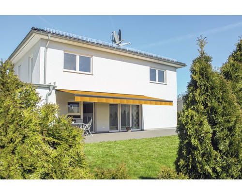 Façade de maison avec store banne jaune au-dessus de la terrasse