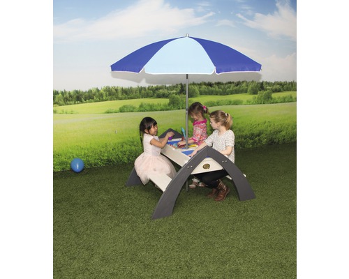 Des enfants sont assis à une table de pique-nique avec parasol à l''extérieur.