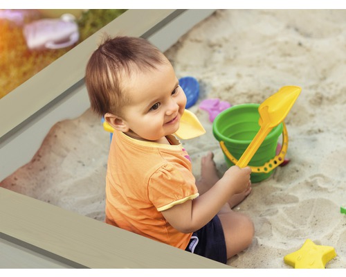 Enfant jouant avec des jouets de bac à sable dans un bac à sable