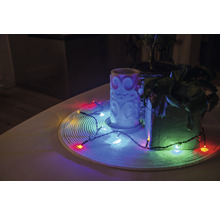 Décoration avec bougie, plantes d'intérieur et guirlande lumineuse sur une table