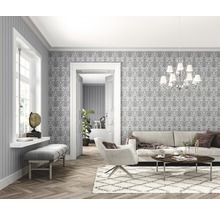 Salon lumineux avec papier peint, canapé, fauteuil et parquet