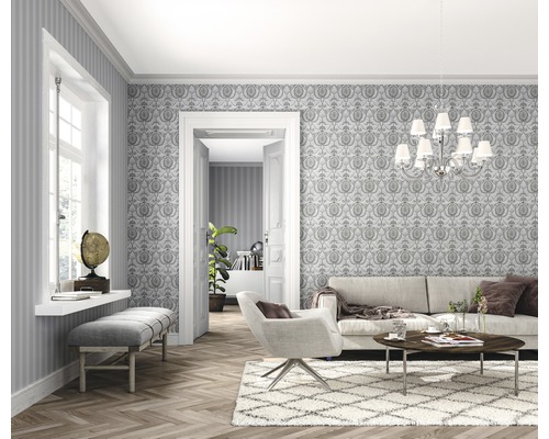 Salon lumineux avec papier peint, canapé, fauteuil et parquet