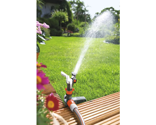 Arroseur de jardin arrose la pelouse dans le jardin
