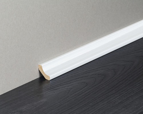 Weisse Sockelleiste aus Holz an Wand und Boden