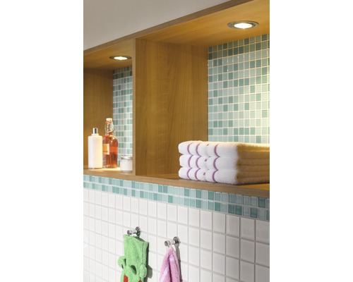 Mur de salle de bain avec étagères, serviettes et carrelage