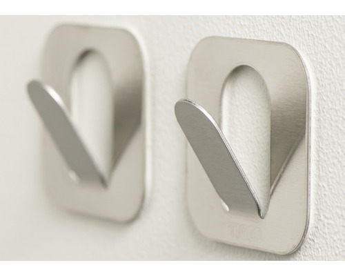 Deux crochets à vêtements métalliques argentés sur un mur