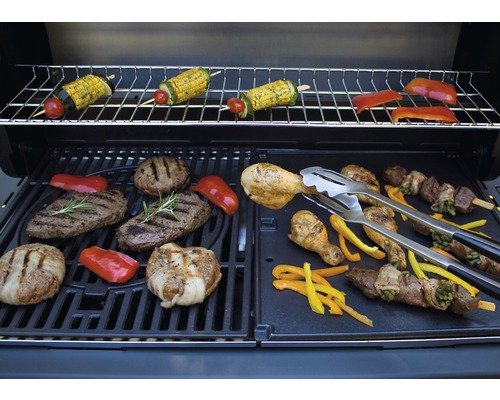 Grill mit Grillgut wie Fleisch, Gemüse und Spießen