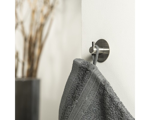 Crochet pour serviette avec serviette grise sur un mur
