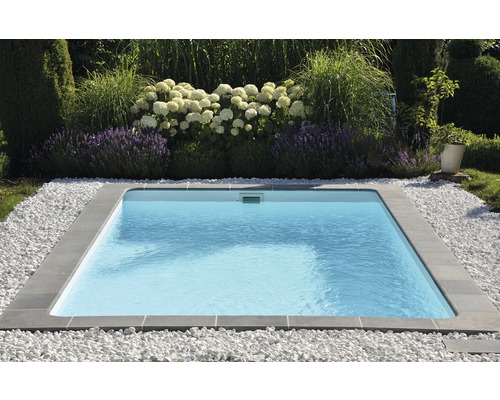 Piscine carrée entourée de pierres dans le jardin