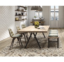 Salle à manger avec table, chaises, banc, tapis à motifs et étagères sur un mur en briques