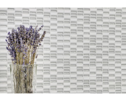 Mur décoratif avec des carreaux de mosaïque de verre et un bouquet de lavande dans un vase