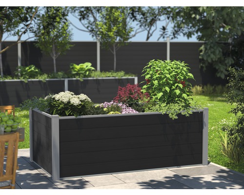 Jardinière surélevée en plastique avec diverses plantes dans le jardin