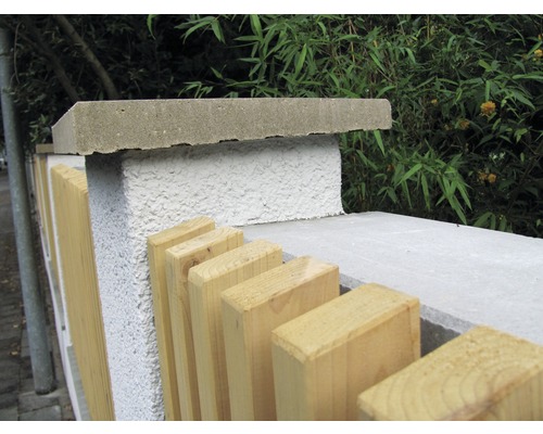 Vue détaillée d''une clôture de jardin avec des poteaux en béton et des éléments en bois