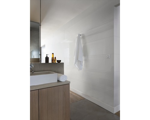 Salle de bain lumineuse avec lavabo, serviette et panneaux muraux